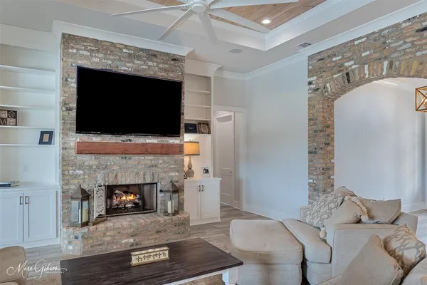 a living room with furniture a flat screen tv and a fireplace