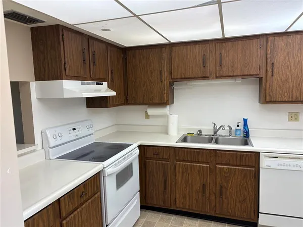 a kitchen with a sink a refrigerator and cabinets
