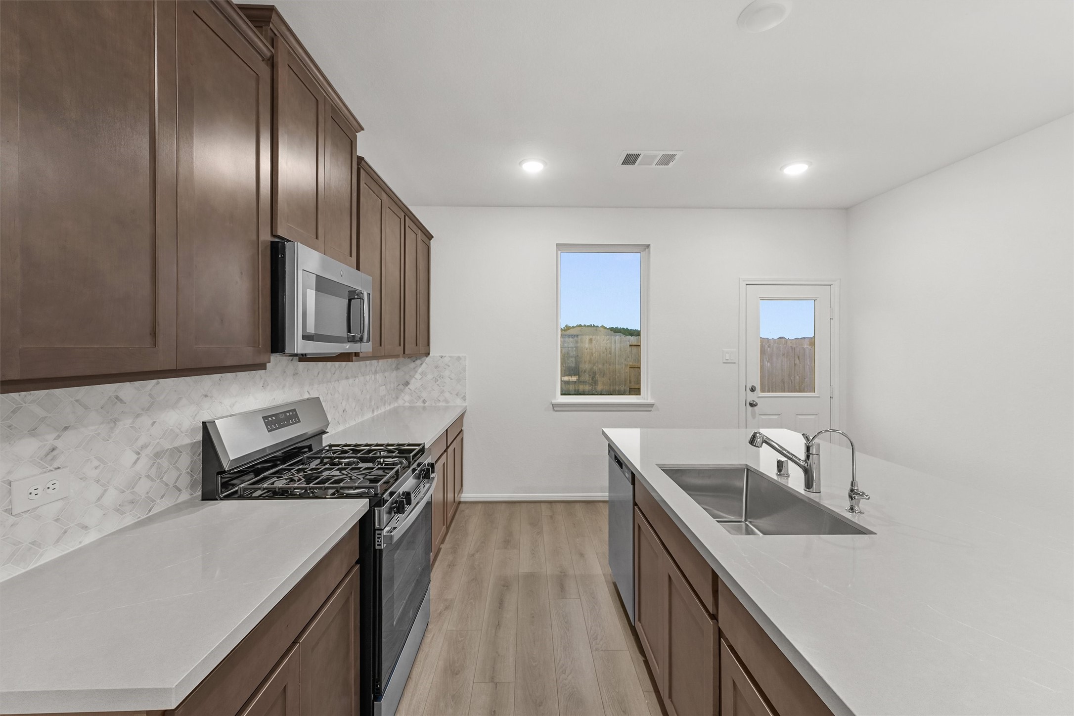 19111 Hazel Firs Court Magnolia, TX 77355 - Photo 14 of 34 a kitchen with stainless steel appliances granite countertop a sink stove and refrigerator