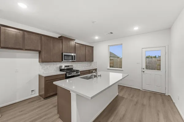 a kitchen with a sink a stove a refrigerator and cabinets