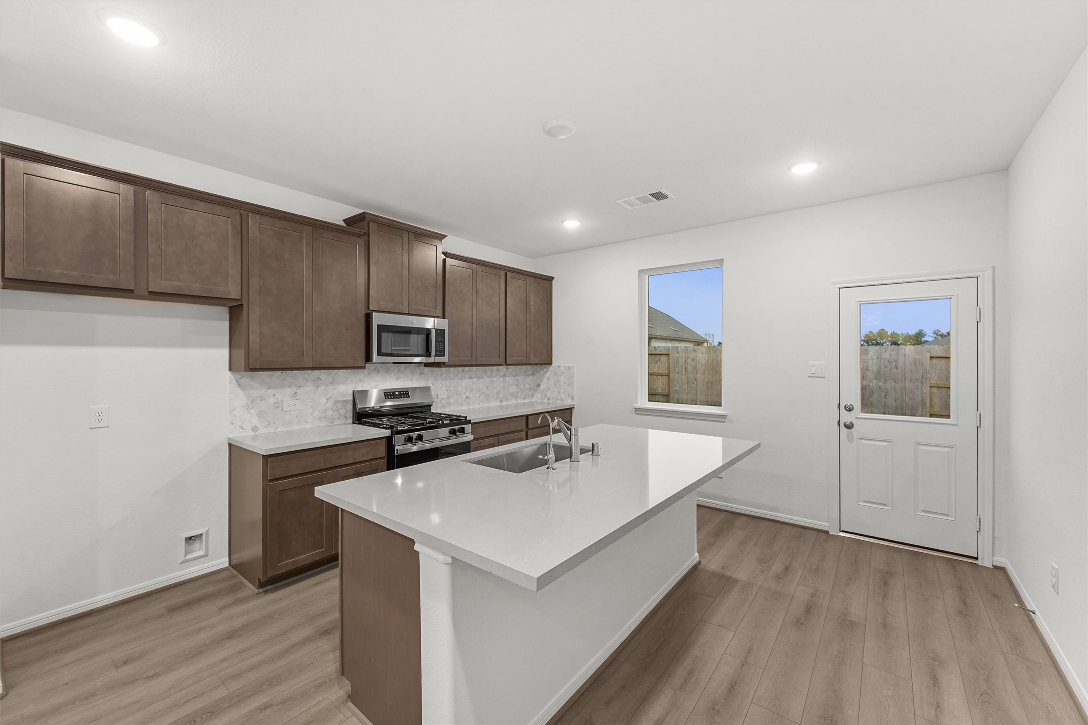 19111 Hazel Firs Court Magnolia, TX 77355 - Photo 15 of 34 a kitchen with a sink a stove a refrigerator and cabinets