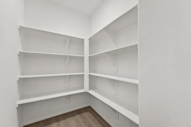 a view of walk in closet with empty racks