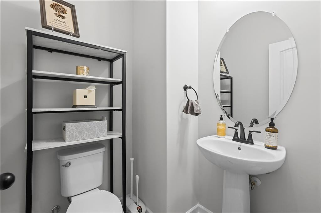 3258 Thicket Lane Atlanta, GA 30349 - Photo 15 of 38 a bathroom with a toilet a sink and a mirror