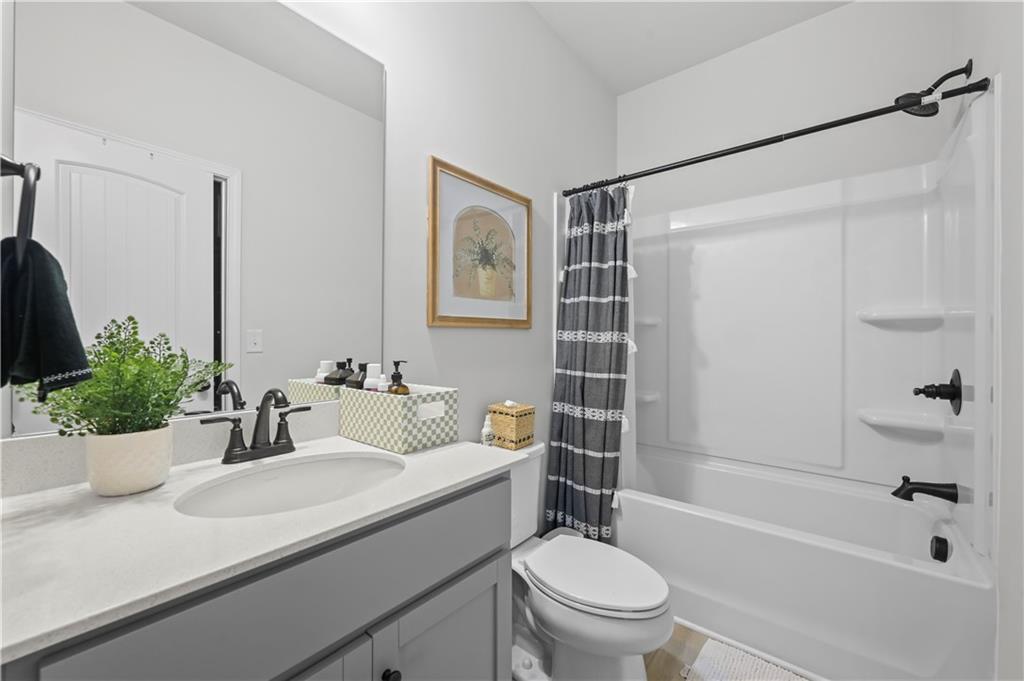 3258 Thicket Lane Atlanta, GA 30349 - Photo 17 of 38 a bathroom with a sink a toilet a mirror a bathtub and shower