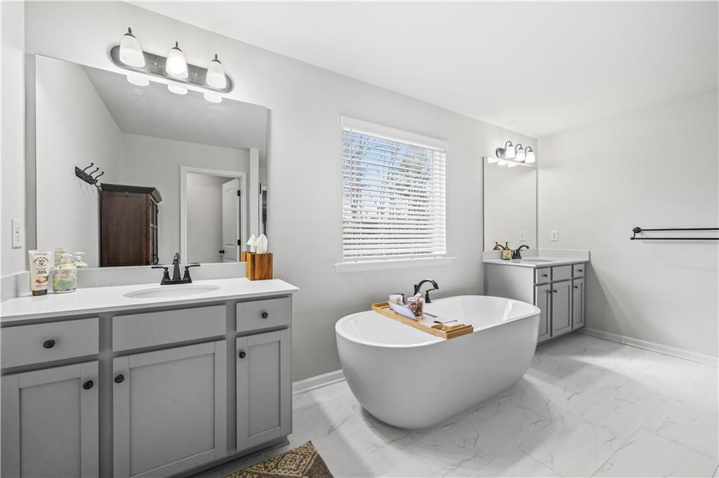 3258 Thicket Lane Atlanta, GA 30349 - Photo 24 of 38 a bathroom with a white tub a sink and mirror