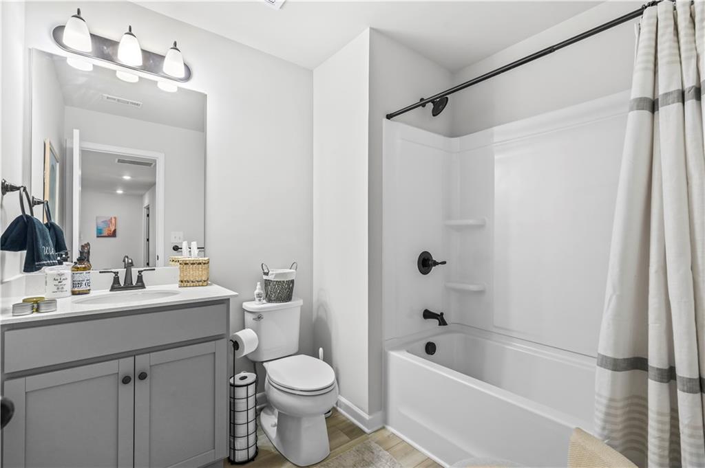 3258 Thicket Lane Atlanta, GA 30349 - Photo 31 of 38 a bathroom with a bathtub shower sink vanity mirror and toilet