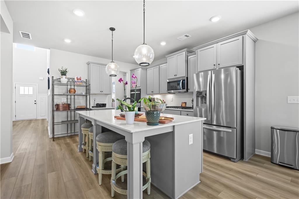 3258 Thicket Lane Atlanta, GA 30349 - Photo 8 of 38 a kitchen with kitchen island a wooden floor and white appliances