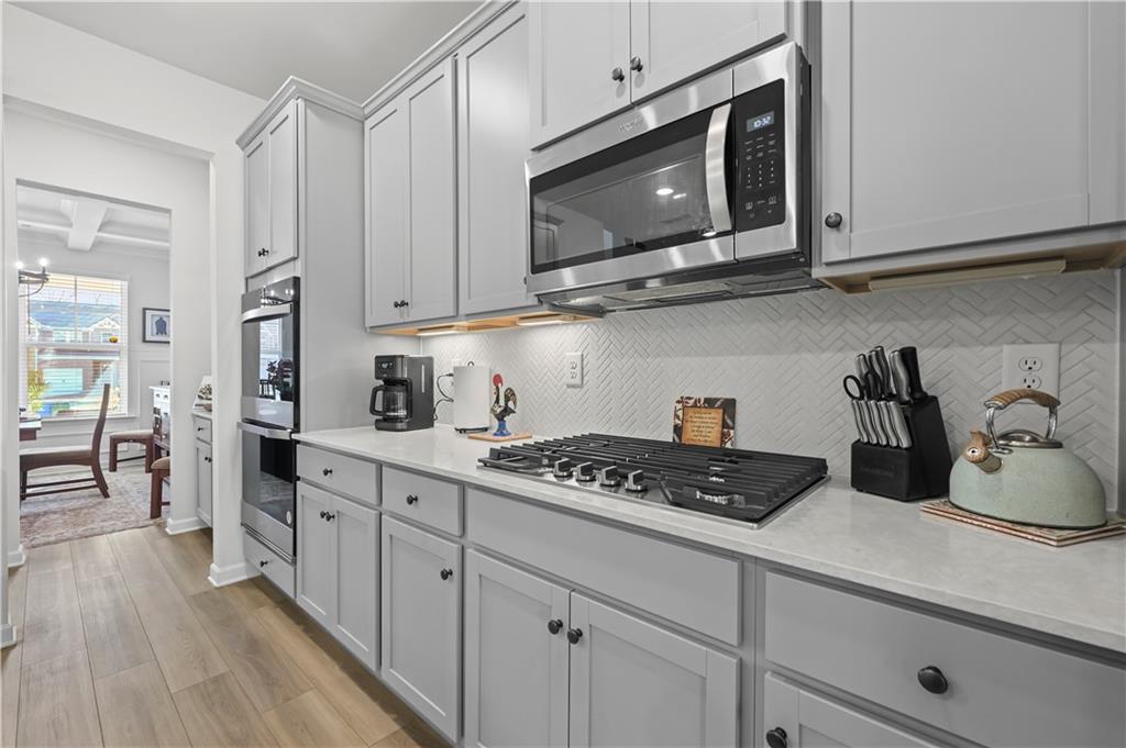 3258 Thicket Lane Atlanta, GA 30349 - Photo 10 of 38 a kitchen with stainless steel appliances granite countertop white cabinets stove top oven and refrigerator