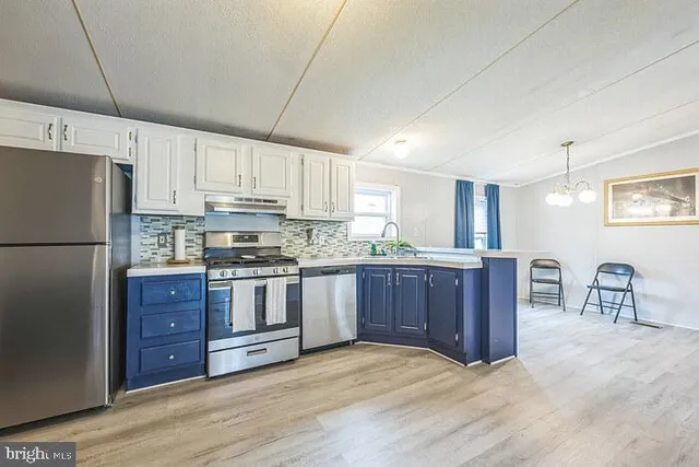 a kitchen with stainless steel appliances granite countertop a refrigerator sink and stove