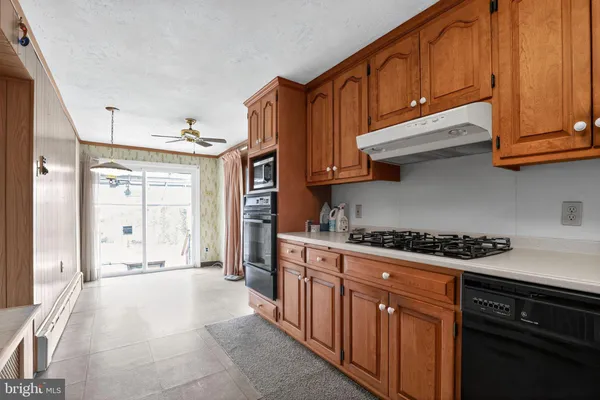 a kitchen with stainless steel appliances granite countertop a stove top oven a sink dishwasher and cabinets with wooden floor