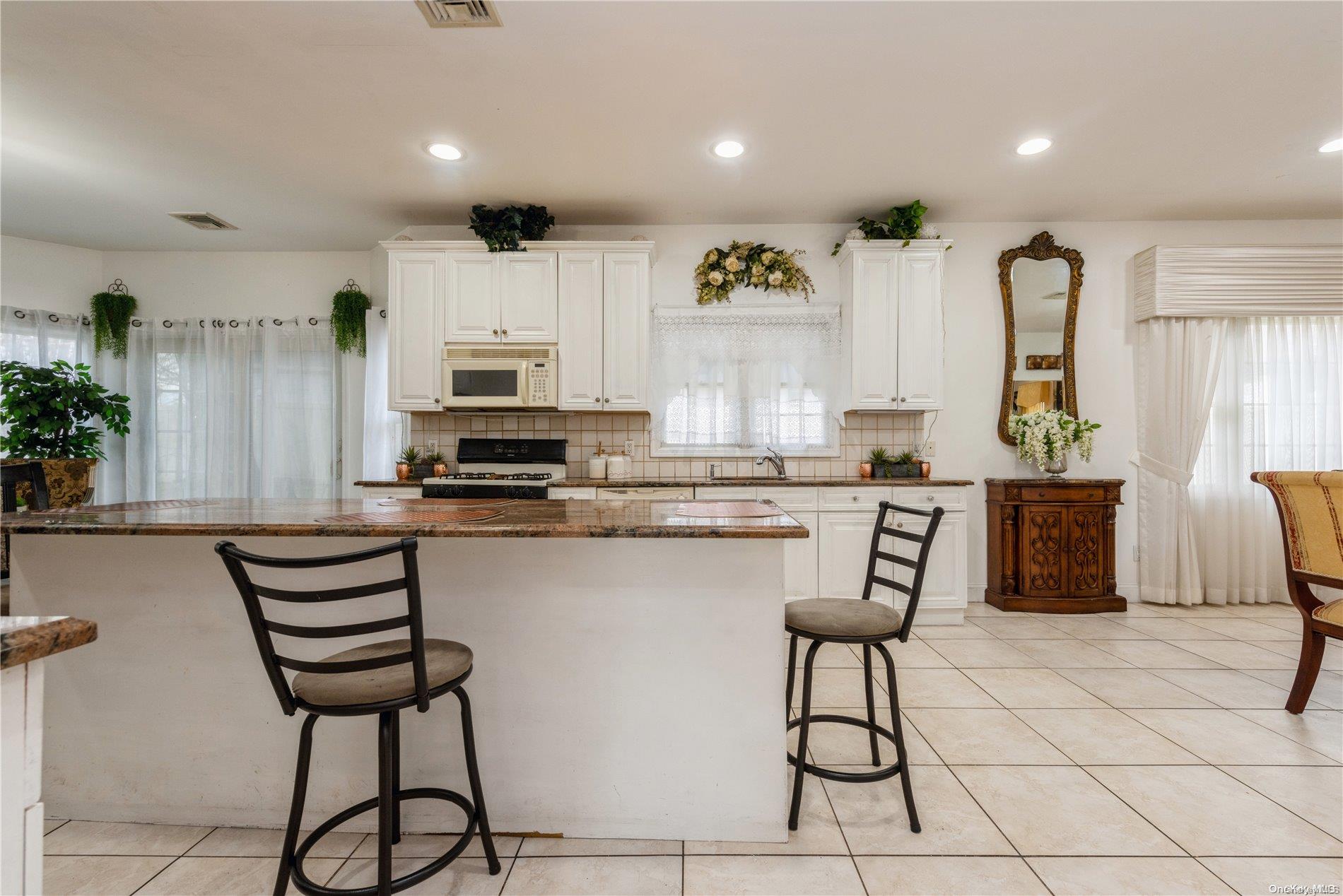 968 Bowe Road Valley Stream, NY 11580 - Photo 16 of 36 a kitchen with stainless steel appliances kitchen island granite countertop a stove a sink and a refrigerator