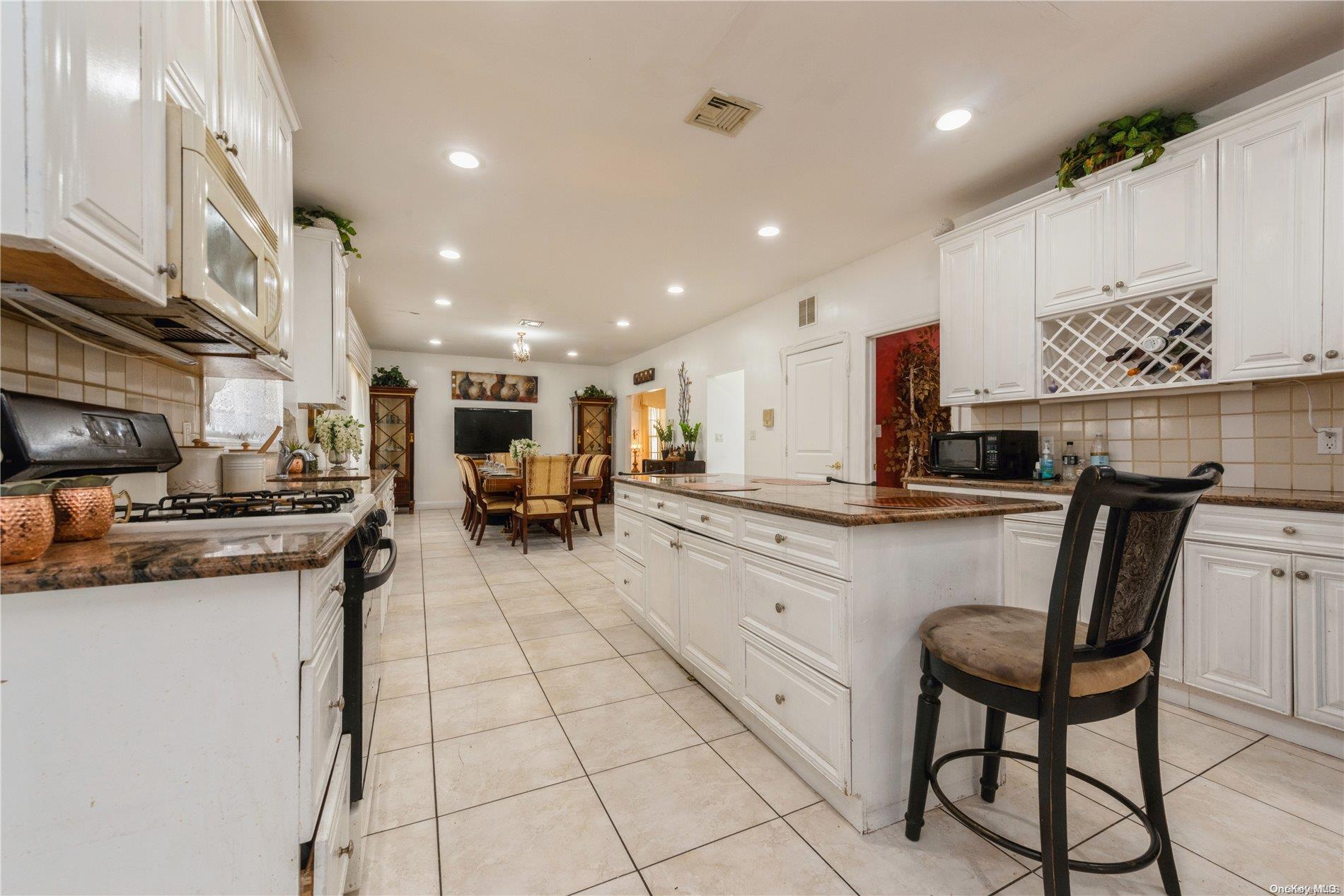 968 Bowe Road Valley Stream, NY 11580 - Photo 17 of 36 a kitchen with stainless steel appliances granite countertop a sink and a refrigerator