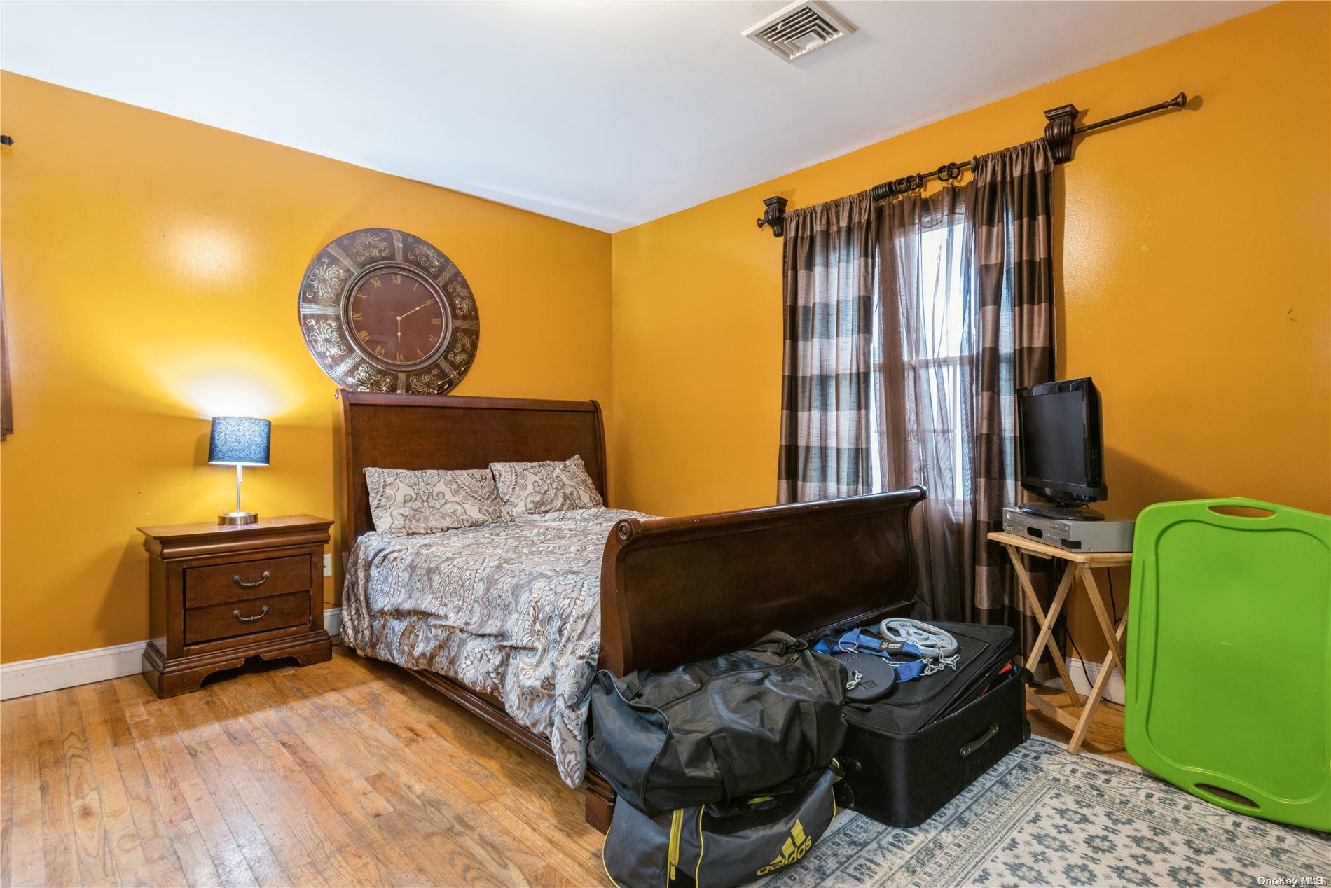 968 Bowe Road Valley Stream, NY 11580 - Photo 26 of 36 a bedroom with a bed and wooden floor