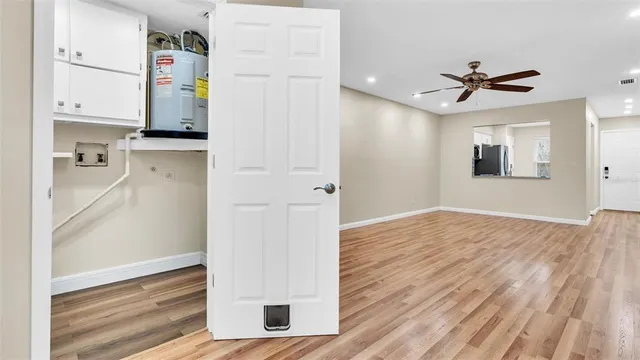 a view of a house with a large tree and wooden fence