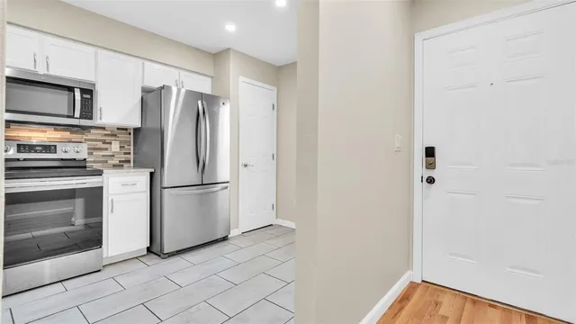 an empty room with wooden floor and a ceiling fan