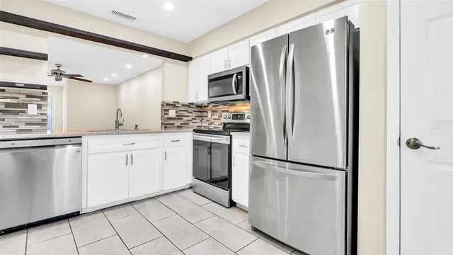 a view of empty room with wooden floor and ceiling fan
