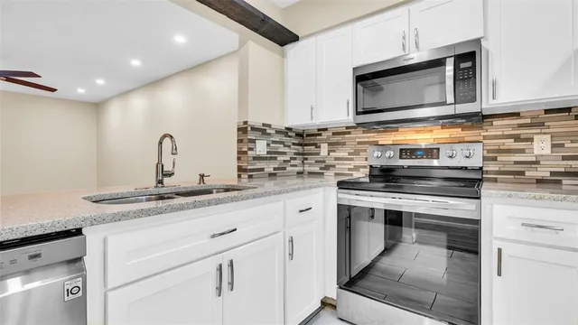 an empty room with wooden floor a ceiling fan and windows
