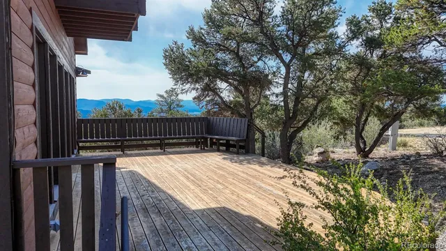 a view of backyard with wooden fence and large trees