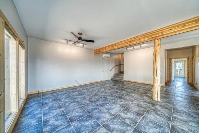 a view of a big room with wooden floor and a ceiling fan