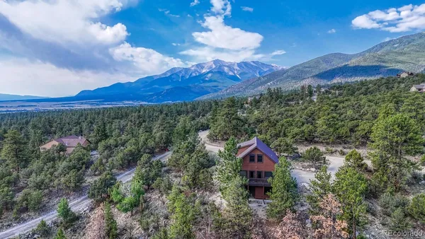 a aerial view of a house with a yard and mountain