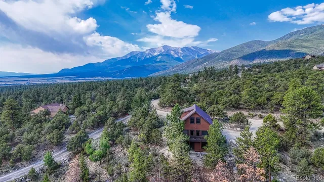 a aerial view of a house with a yard and mountain