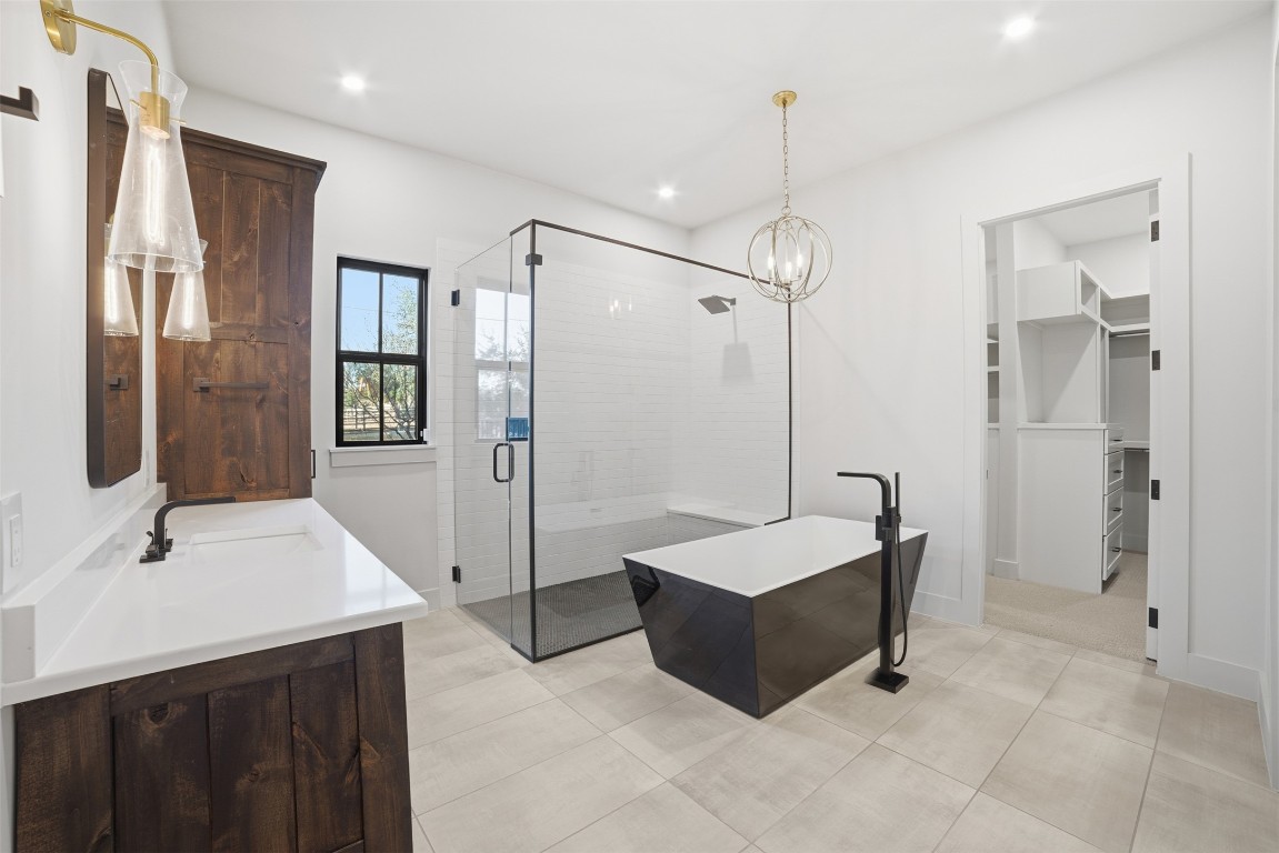 23937 Oscar Road Spicewood, TX 78669 - Photo 15 of 36 a spacious bathroom with a shower sink and mirror