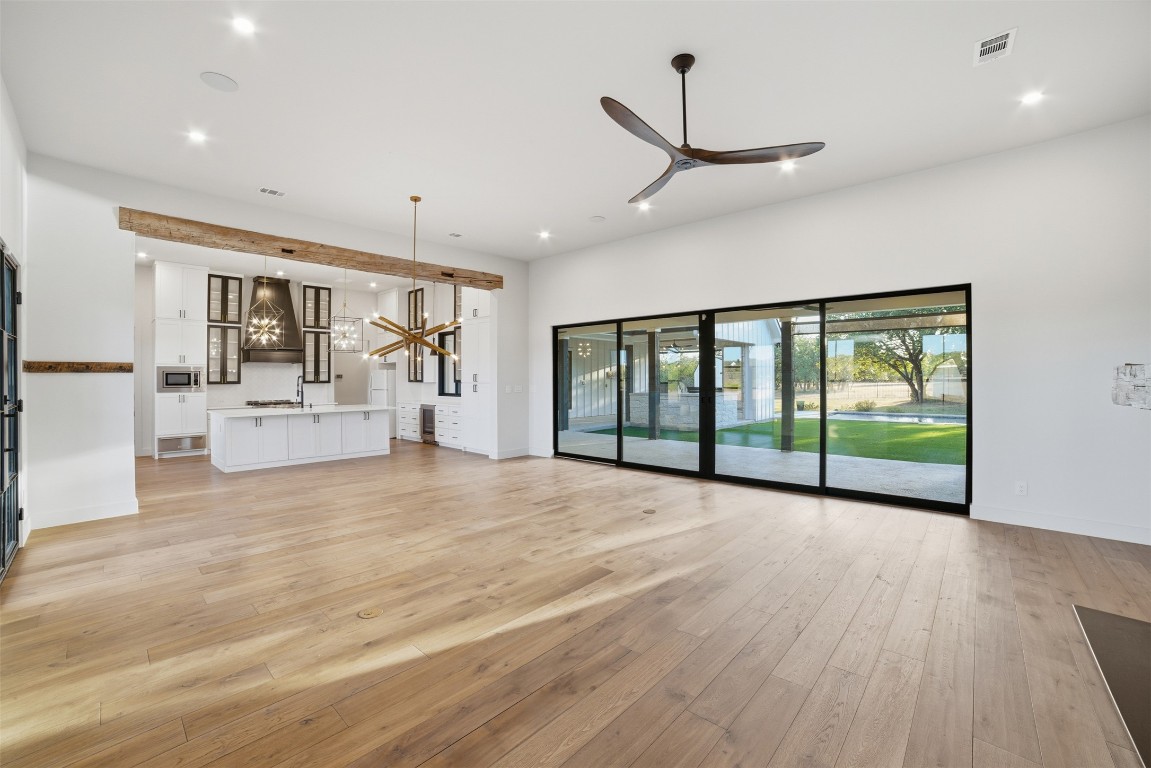 23937 Oscar Road Spicewood, TX 78669 - Photo 6 of 36 a view of an empty room with a window and a chandelier