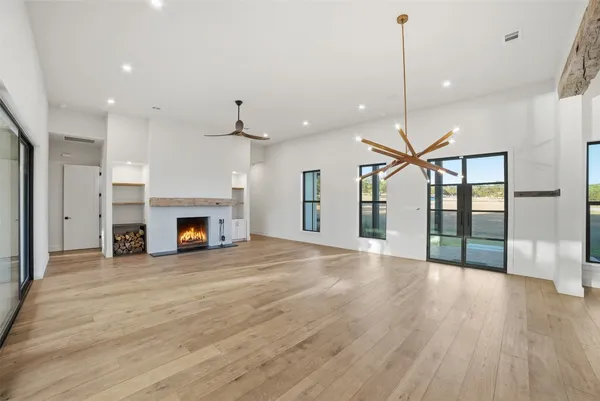 a view of an empty room with a fireplace and a floor to ceiling window