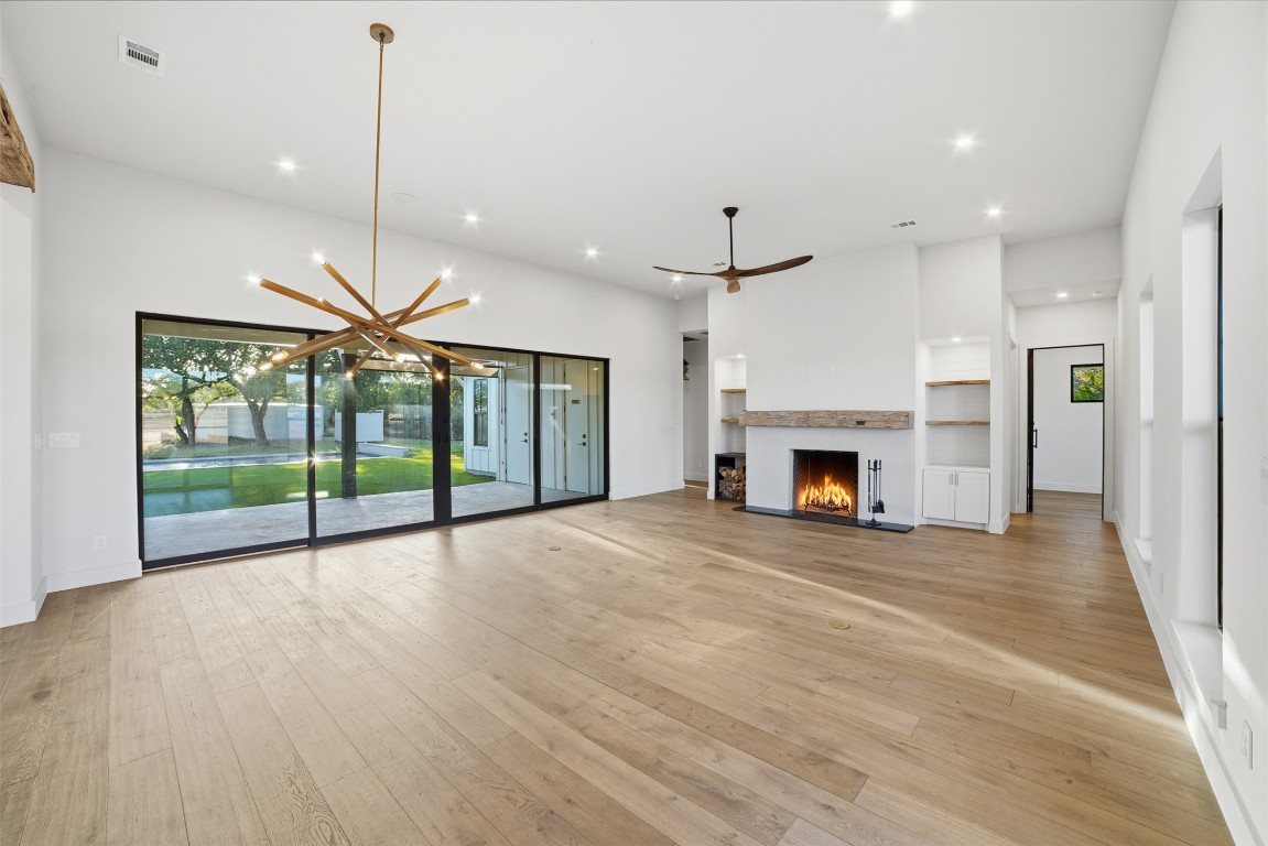 23937 Oscar Road Spicewood, TX 78669 - Photo 9 of 36 a view of an empty room with a fireplace and a floor to ceiling window