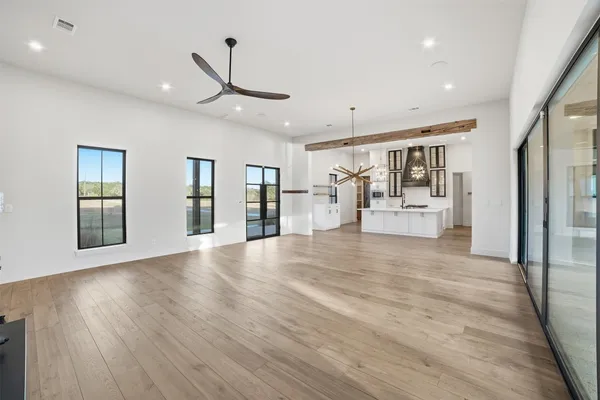 a large white kitchen with a sink stainless steel appliances and cabinets