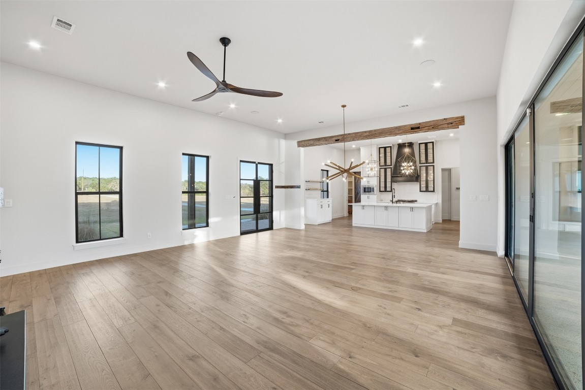 23937 Oscar Road Spicewood, TX 78669 - Photo 10 of 36 a view of an empty room with wooden floor and a window