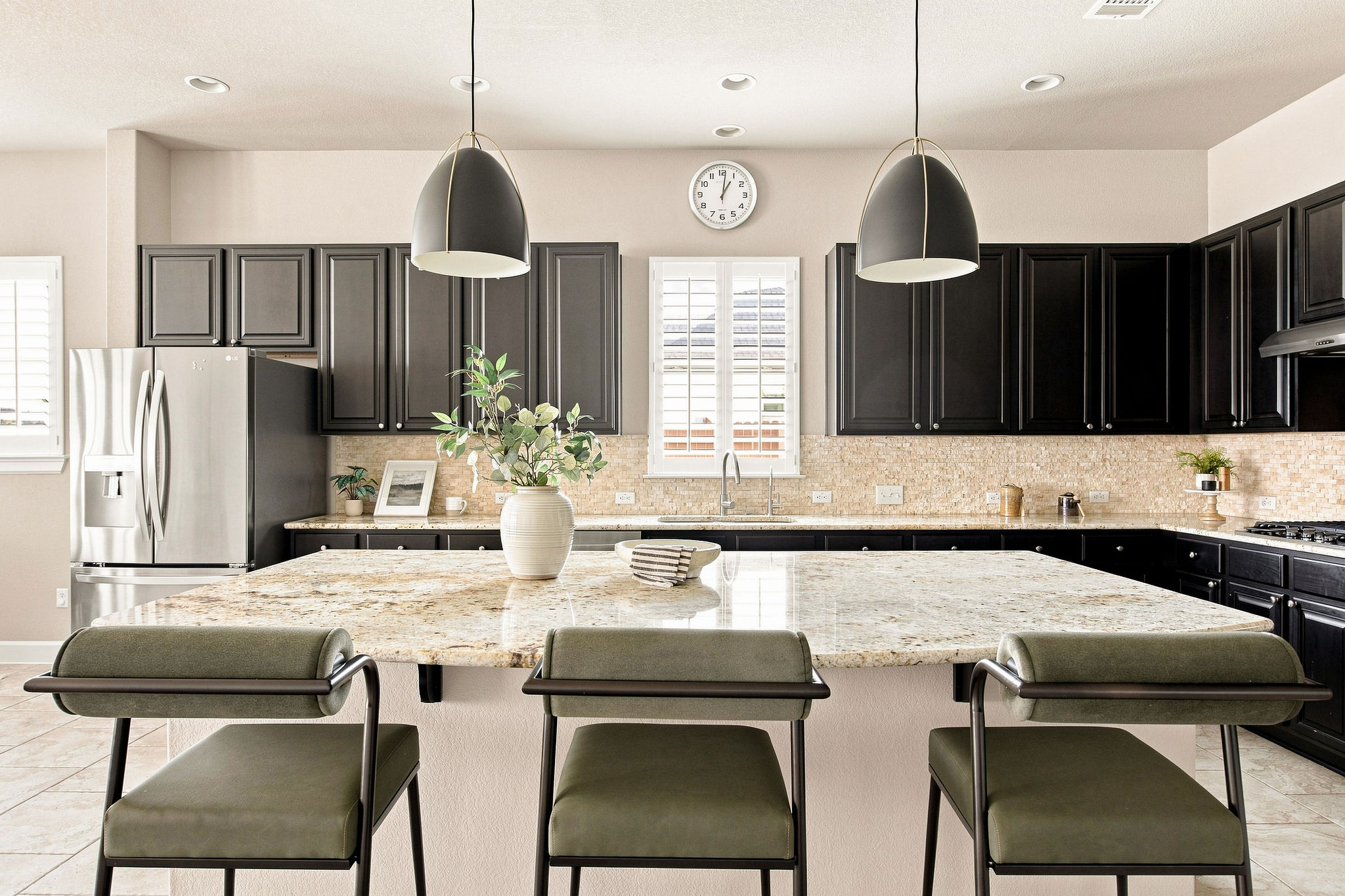 Granite countertops and dark cabinetry create a classic culinary space centered around a spacious island.