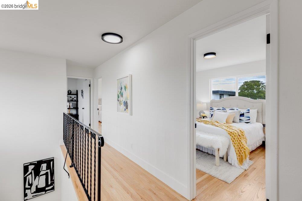 1298 Ribbon Street Foster City, CA 94404 - Photo 44 of 86 Bright hallway featuring light wood-finish flooring, white walls, and a black wrought iron railing