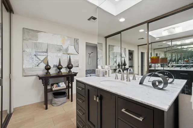 a bathroom with a sink double vanity granite and a shower
