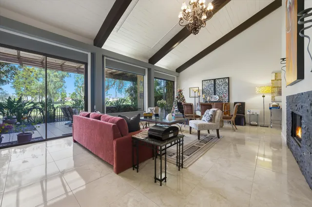 a living room with furniture a fireplace and a large window
