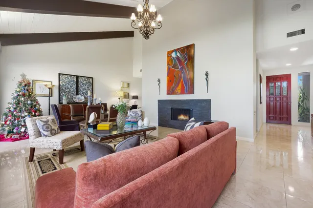 a living room with furniture a fireplace and a chandelier