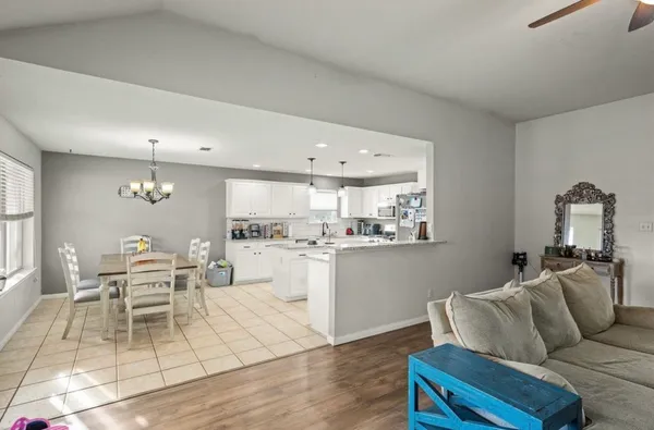 a living room with furniture and view of kitchen