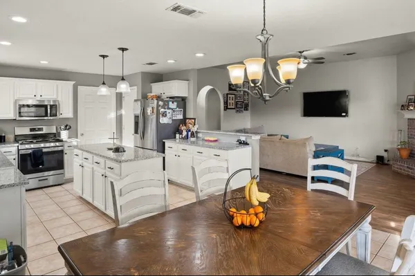 a kitchen with stainless steel appliances granite countertop a stove refrigerator and cabinets