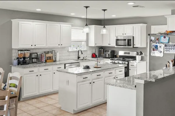 a kitchen with cabinets appliances a sink and a counter top space