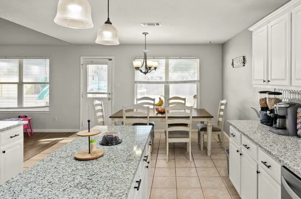 a kitchen with sink refrigerator dining table and chairs