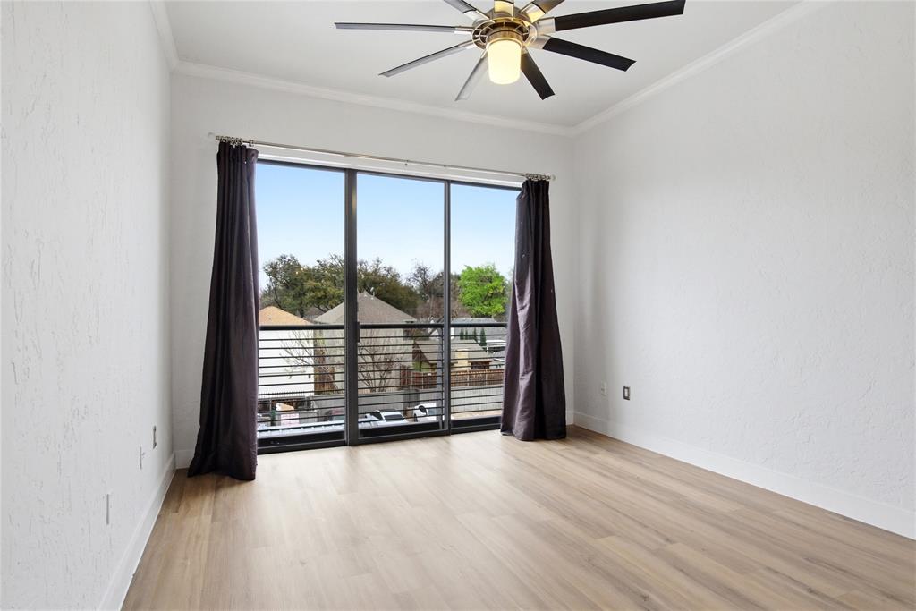4414 Cedar Springs Road, Unit 312 Dallas, TX 75219 - Photo 13 of 30 an empty room with chandelier fan and windows