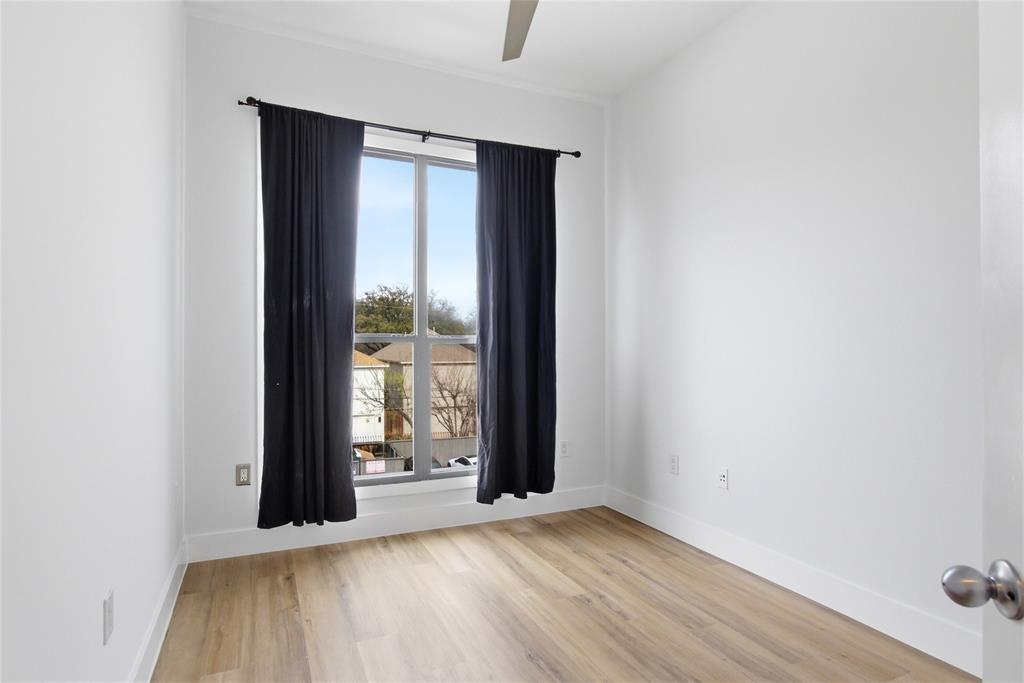 4414 Cedar Springs Road, Unit 312 Dallas, TX 75219 - Photo 18 of 30 an empty room with wooden floor and windows