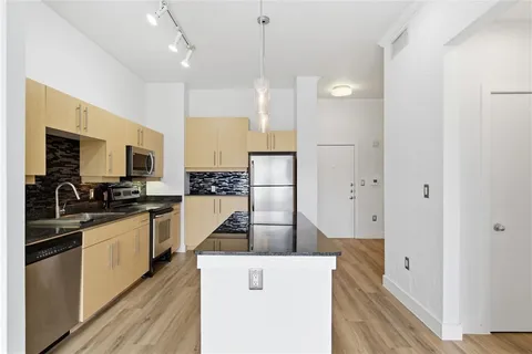 a kitchen with stainless steel appliances granite countertop a sink a stove and a refrigerator