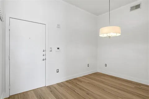 a view of a small space with wooden floor and a window