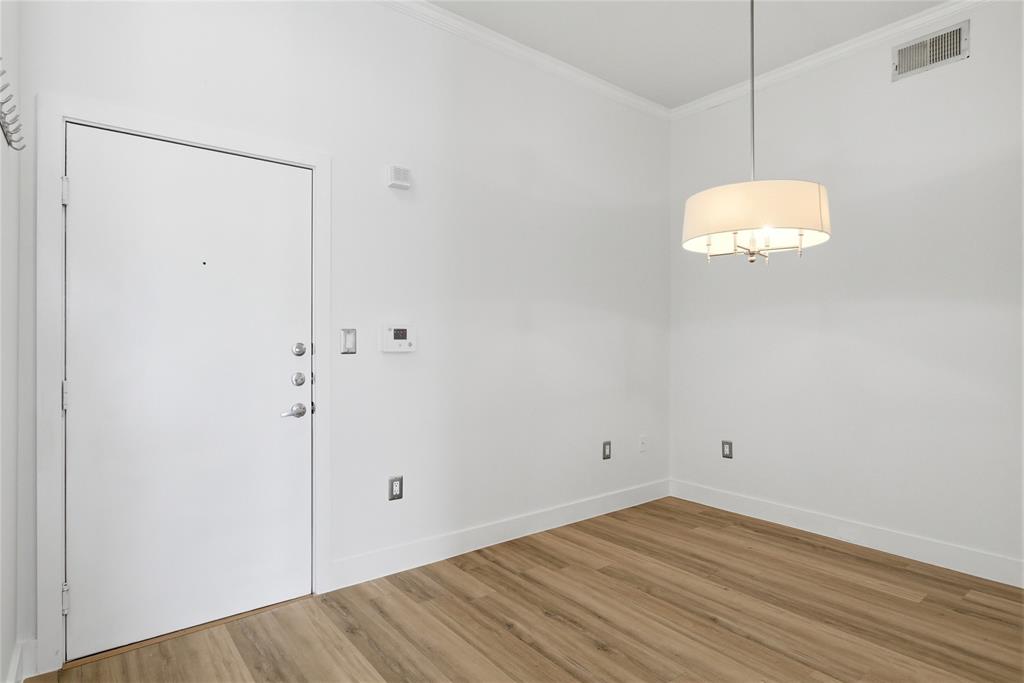4414 Cedar Springs Road, Unit 312 Dallas, TX 75219 - Photo 28 of 30 an empty room with wooden floor and windows