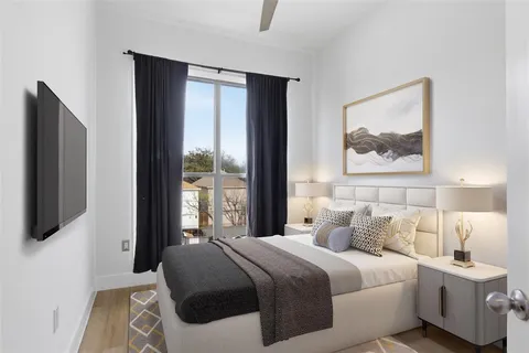 a bedroom with a large bed and a flat tv screen on dresser