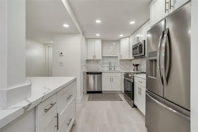 a kitchen with a sink stainless steel appliances and cabinets