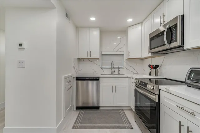 a kitchen with refrigerator and chairs