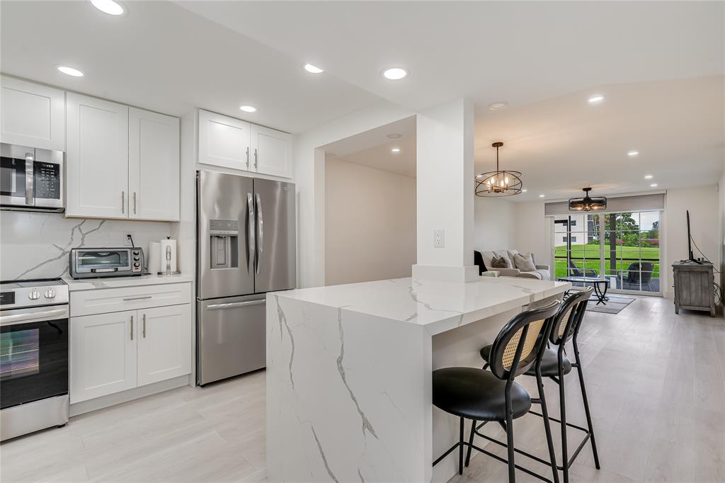 411 South Hollybrook Drive, Unit 109 Pembroke Pines, FL 33025 - Photo 12 of 61 a kitchen with refrigerator and chairs
