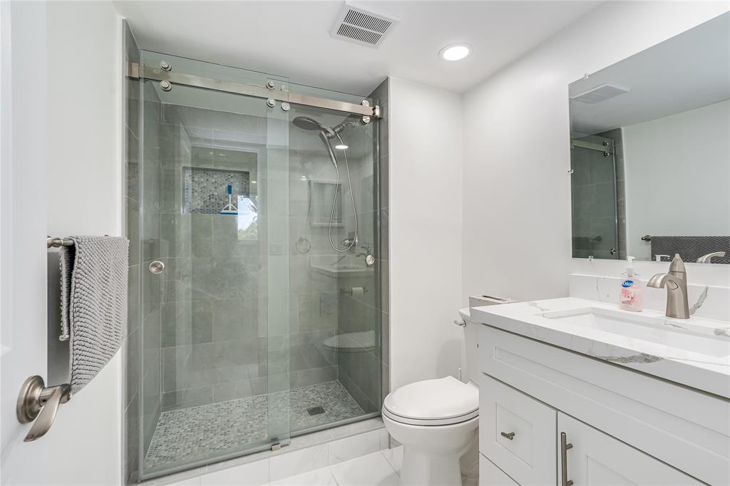 411 South Hollybrook Drive, Unit 109 Pembroke Pines, FL 33025 - Photo 5 of 61 a bathroom with a shower sink vanity mirror and toilet